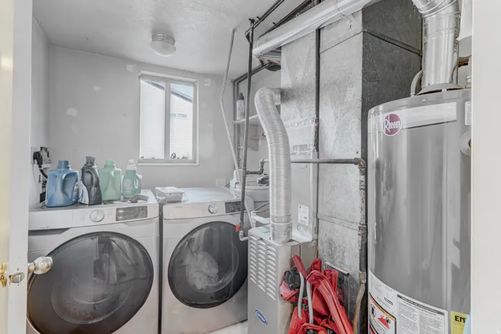 Utility room featuring a water heater, furnace, and a window