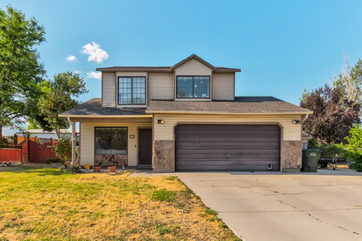 Two-story residence featuring composite siding, stone veneer accents, an attached two-car garage, and a concrete driveway
