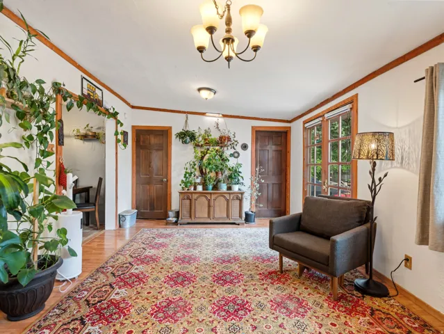 Wood-finish flooring, wood-framed windows, and a multi-bulb chandelier