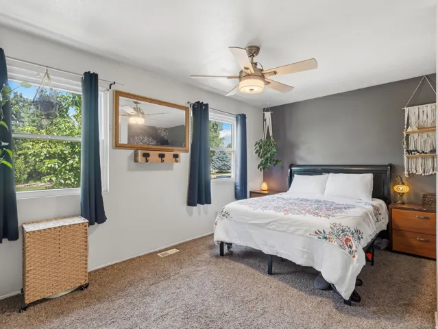 Wall-to-wall carpeting and a ceiling fan with integrated lighting