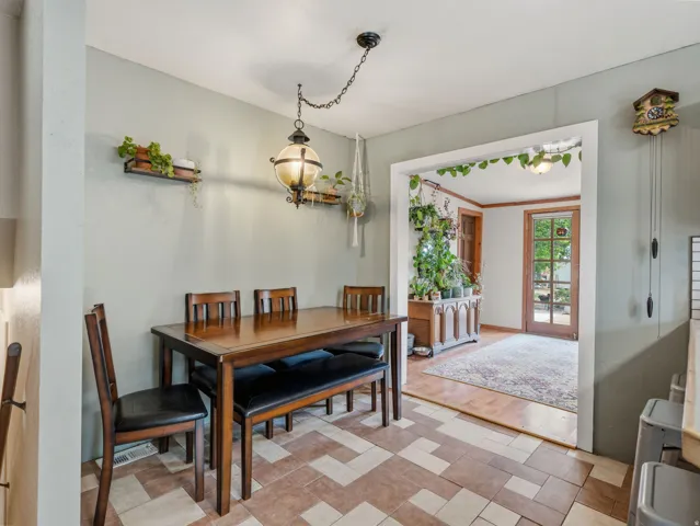 Tile flooring with geometric patterns, a ceiling-mounted light fixture, and an open doorway with wood trim