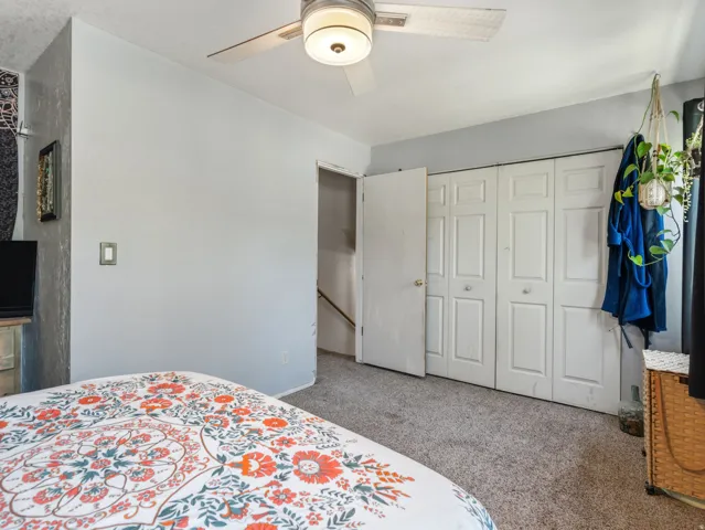 Wall-to-wall carpeting with bi-fold closet doors and a ceiling fan with integrated lighting