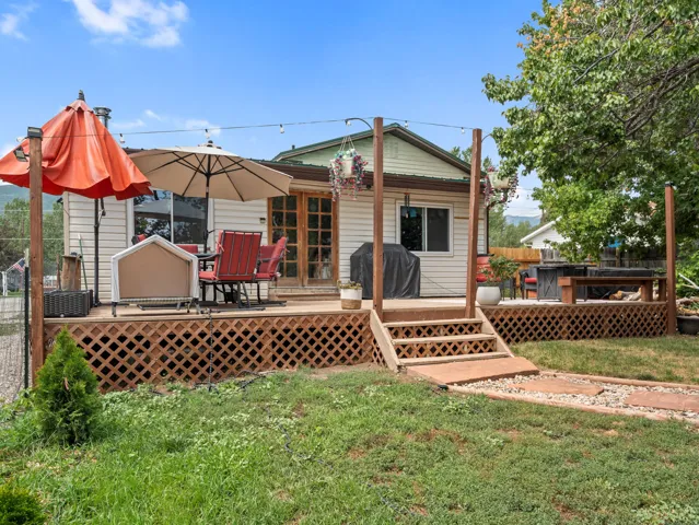 Split-level wooden deck with lattice skirting, featuring integrated wooden posts and a stone-lined pathway