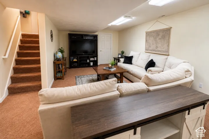 Finished lower level with carpeted flooring and stairway