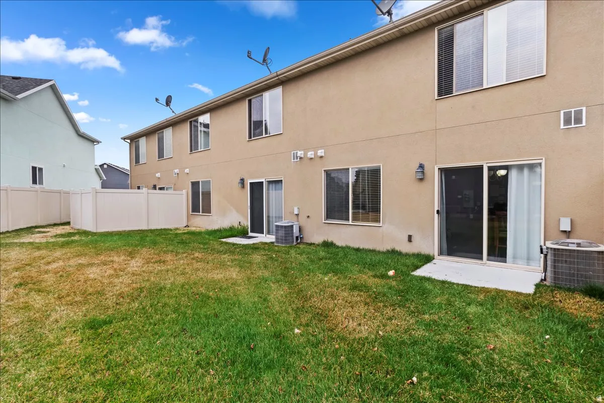 Rear exterior featuring stucco siding, multiple windows, and sliding glass door access to the outdoor space