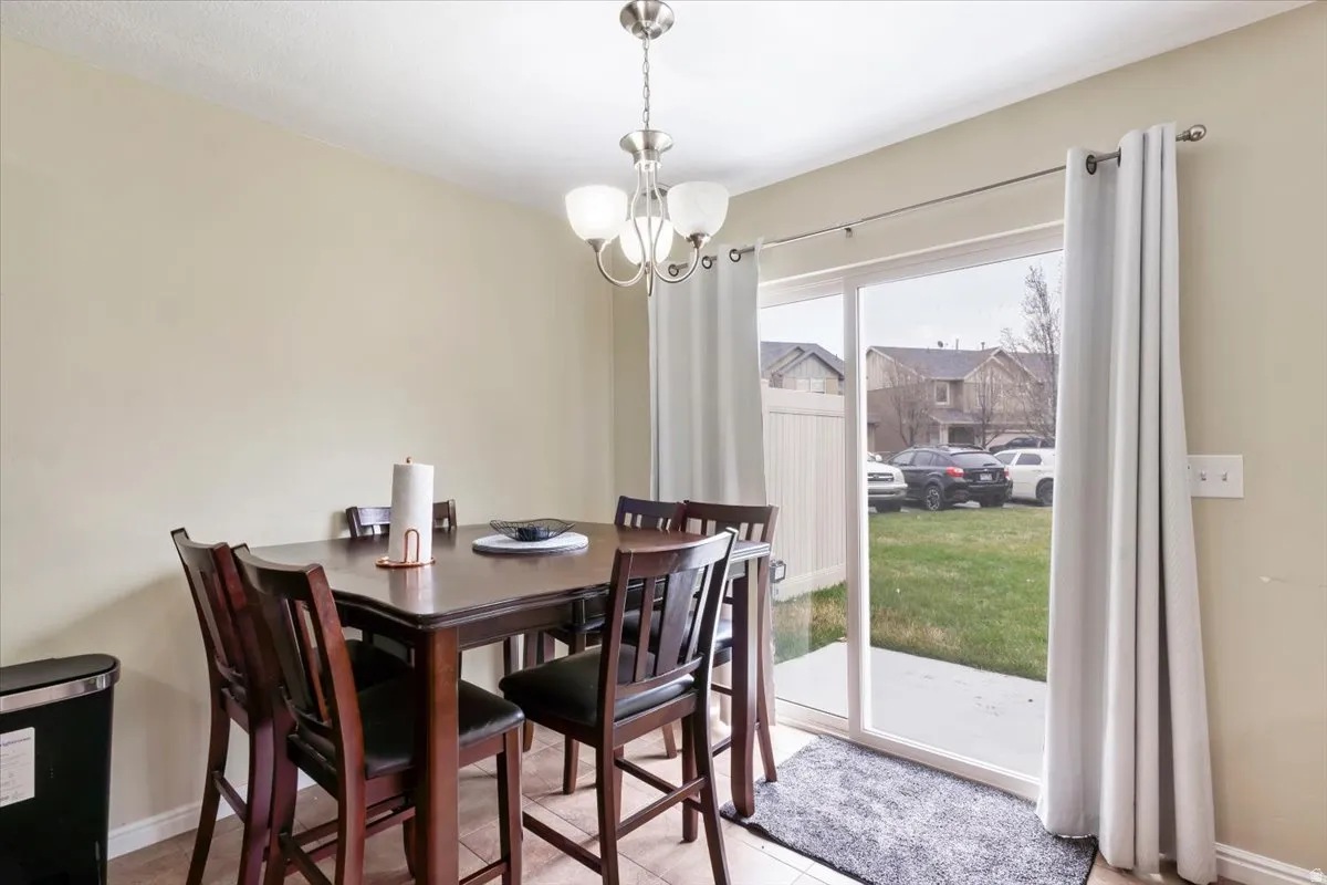 Recessed lighting and a glass-enclosed chandelier illuminate the dining area