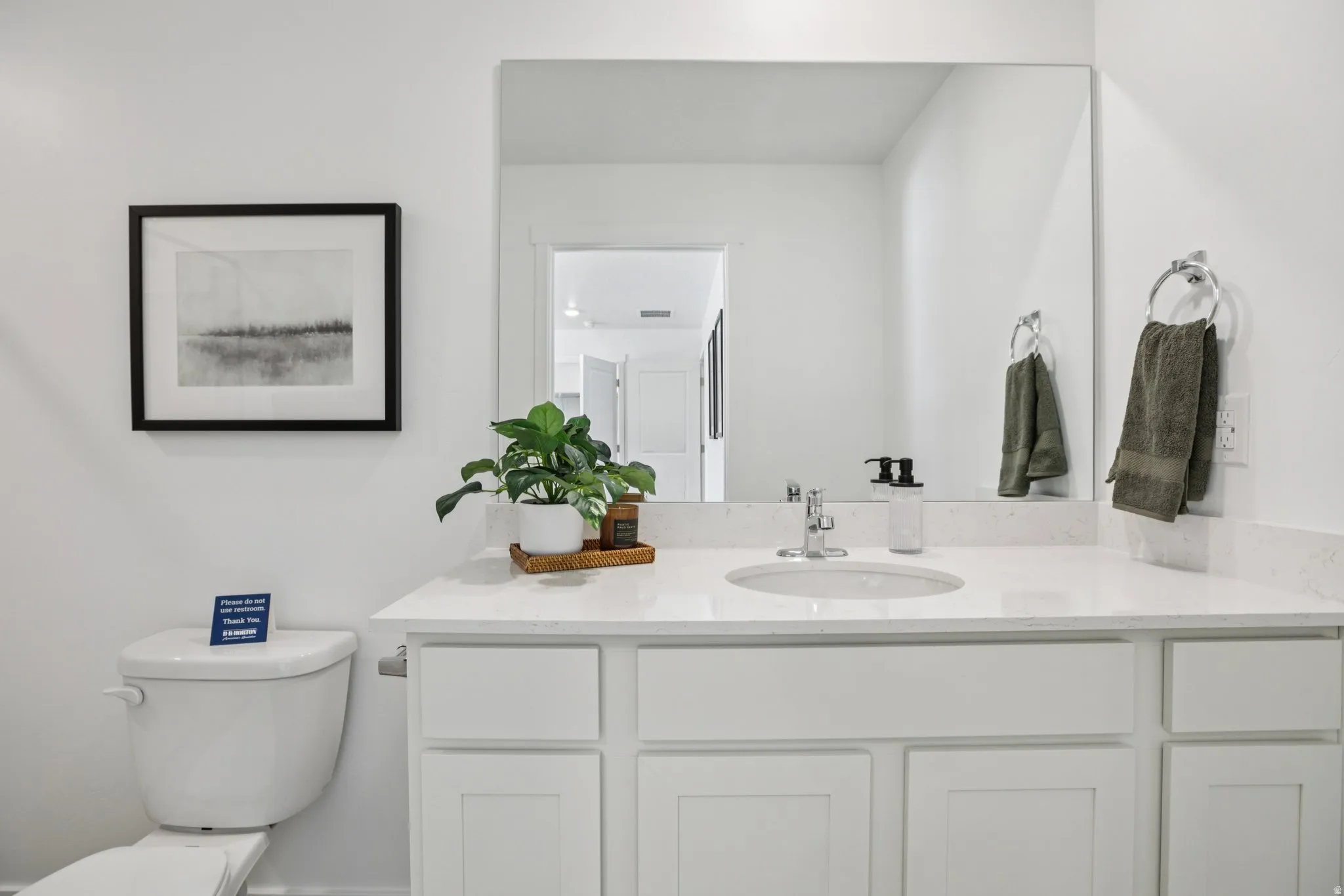 White vanity with shaker-style cabinetry, an integrated sink, and a light-toned countertop