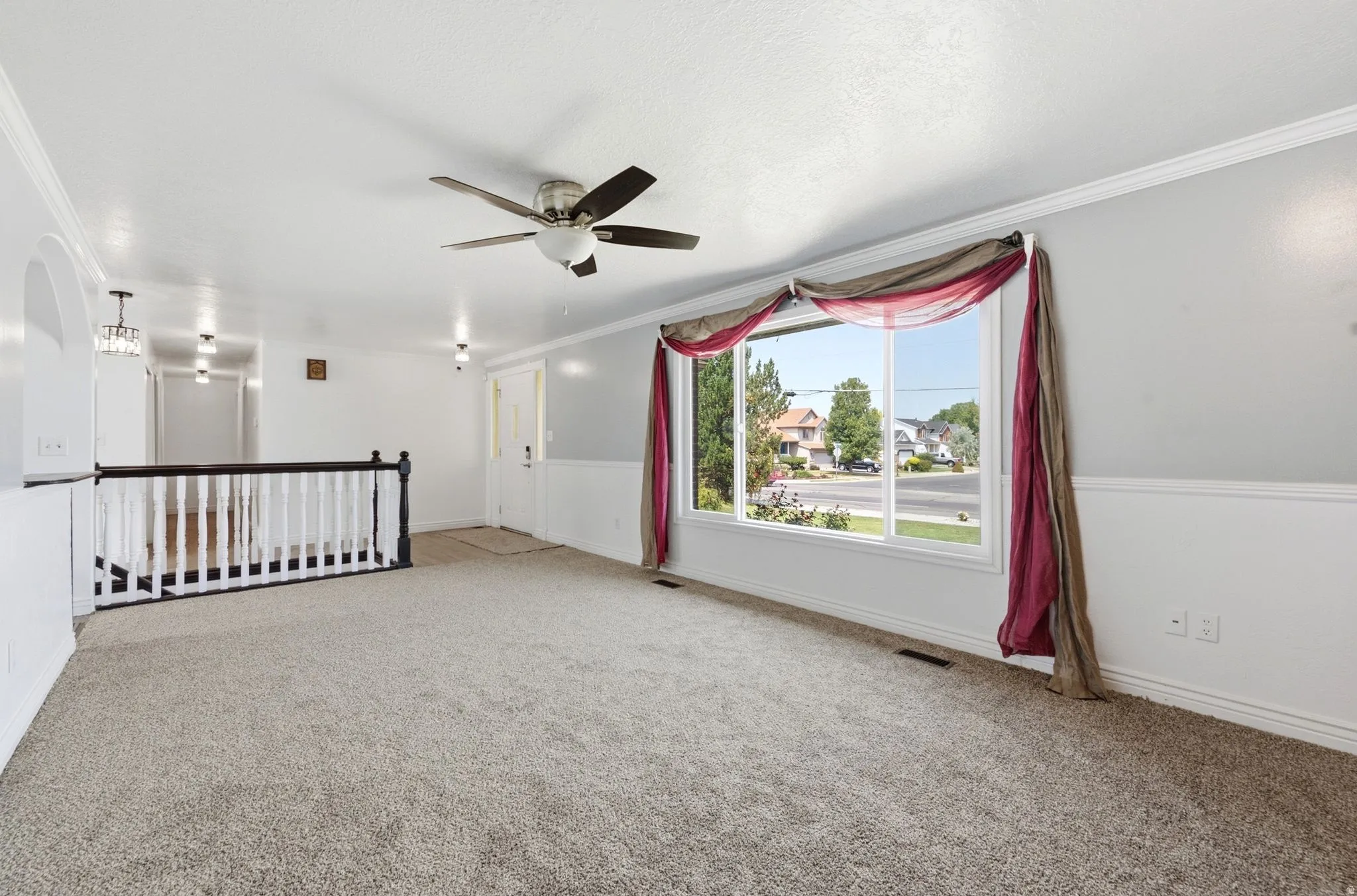 Open-concept area with light gray carpet and white walls