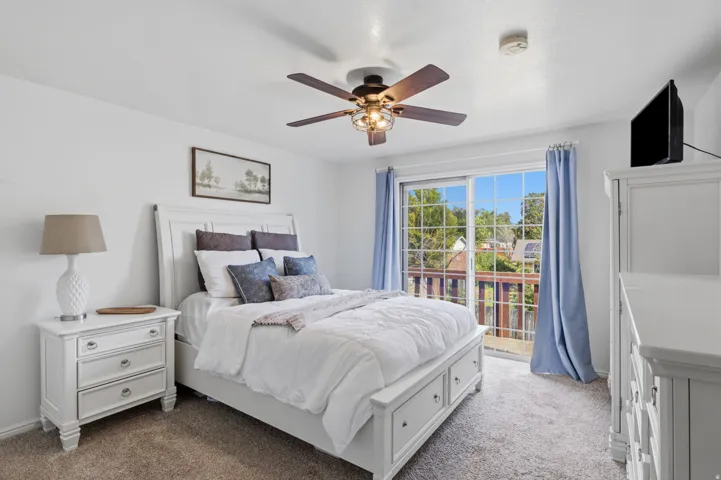 Sliding glass door, outdoor balcony, ceiling fan, and carpeted flooring
