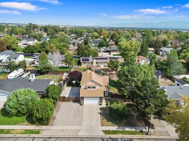 Two-story exterior with an attached garage, paved driveway, and gravel parking area