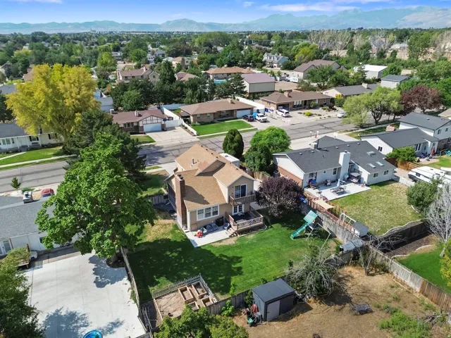 Expansive backyard featuring a manicured lawn, established trees, and a spacious elevated deck