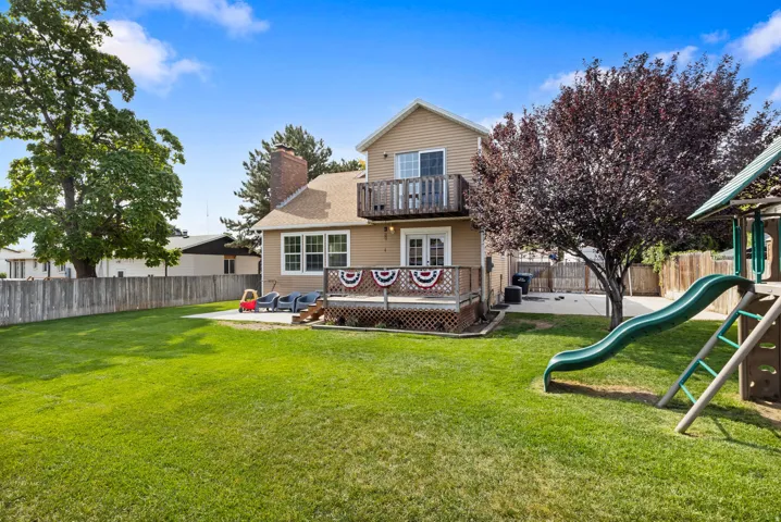 Expansive grass lawn with mature trees and a wood-fenced perimeter