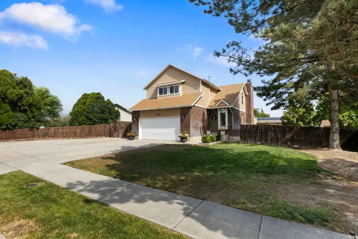 Two-story property featuring a front-facing attached garage, brick facade, bay window, and a gabled roof