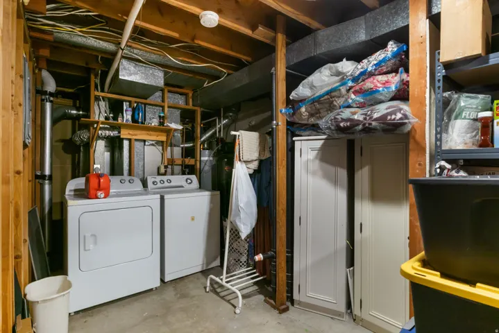 Laundry area with exposed wood framing, ductwork, and utility shelving