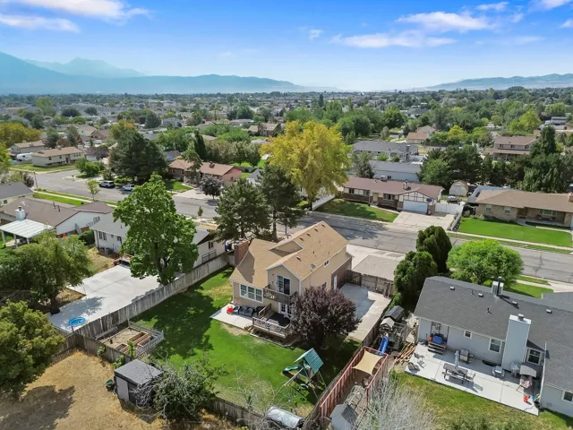 Expansive lot featuring a large rear patio, wood deck, and detached storage shed