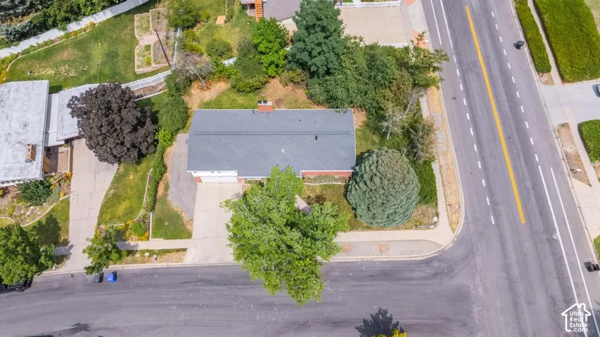Corner lot with established landscaping, concrete driveway, paved RV parking and mature trees