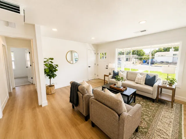 Recessed lighting, wood-finish flooring, white paneled walls, and a large picture window