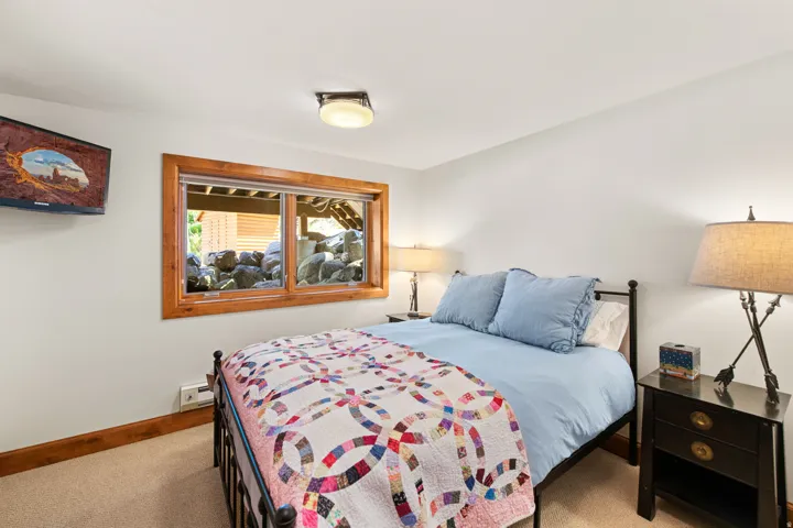Carpeted flooring, wood-framed window, and a ceiling-mounted light fixture