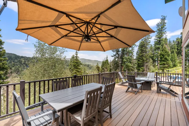 Expansive outdoor deck with wood-finish flooring, sturdy railing, and a large umbrella