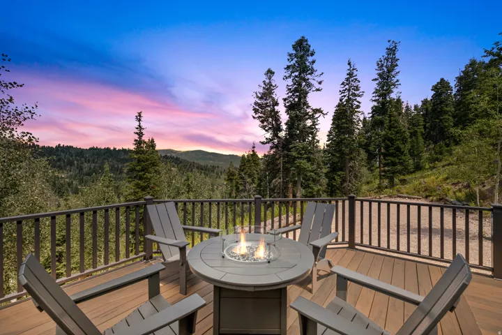 Expansive outdoor deck featuring wood-finish flooring, a built-in fire pit, and surrounding railing