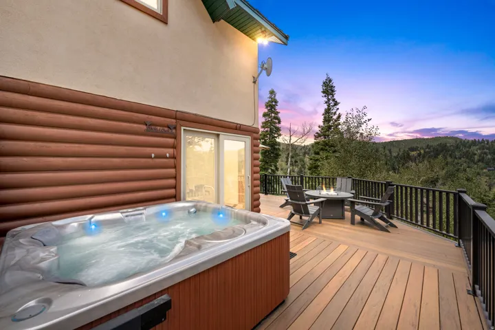 Expansive outdoor deck with a built-in hot tub, durable wood-finish decking, and black metal railings