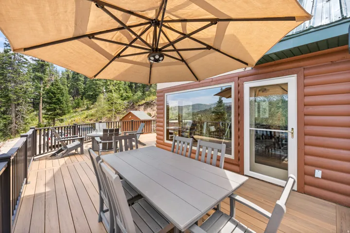 Expansive outdoor deck featuring wood-finish flooring, dark-toned railings, and a large window
