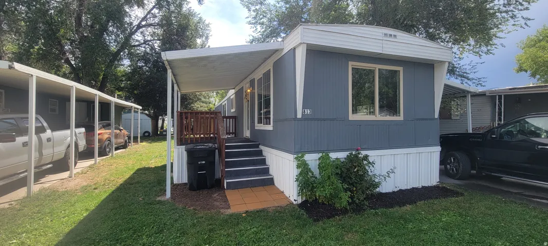Exterior featuring siding, multiple windows, a covered entry, and a carport