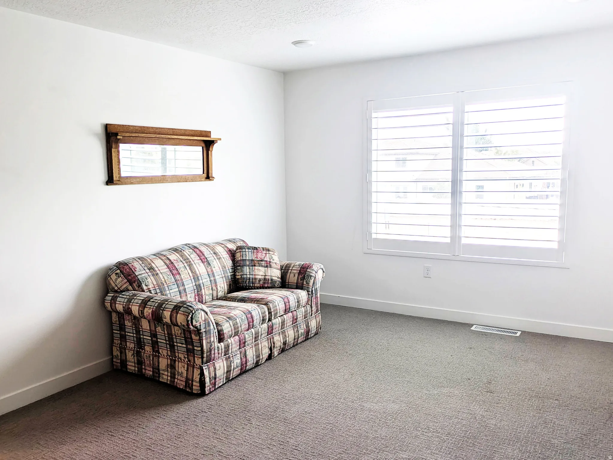Recessed lighting illuminates the space, featuring white walls and a carpeted floor