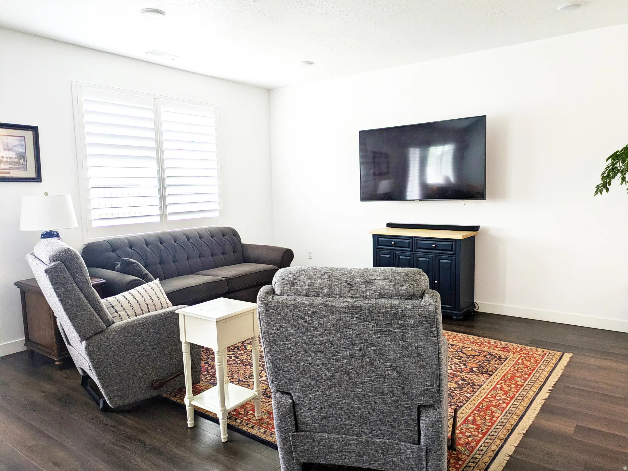 Wood-finish flooring with white walls and recessed lighting
