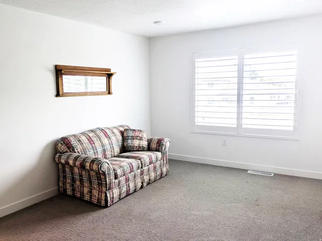 Recessed lighting illuminates the space, featuring white walls and a carpeted floor