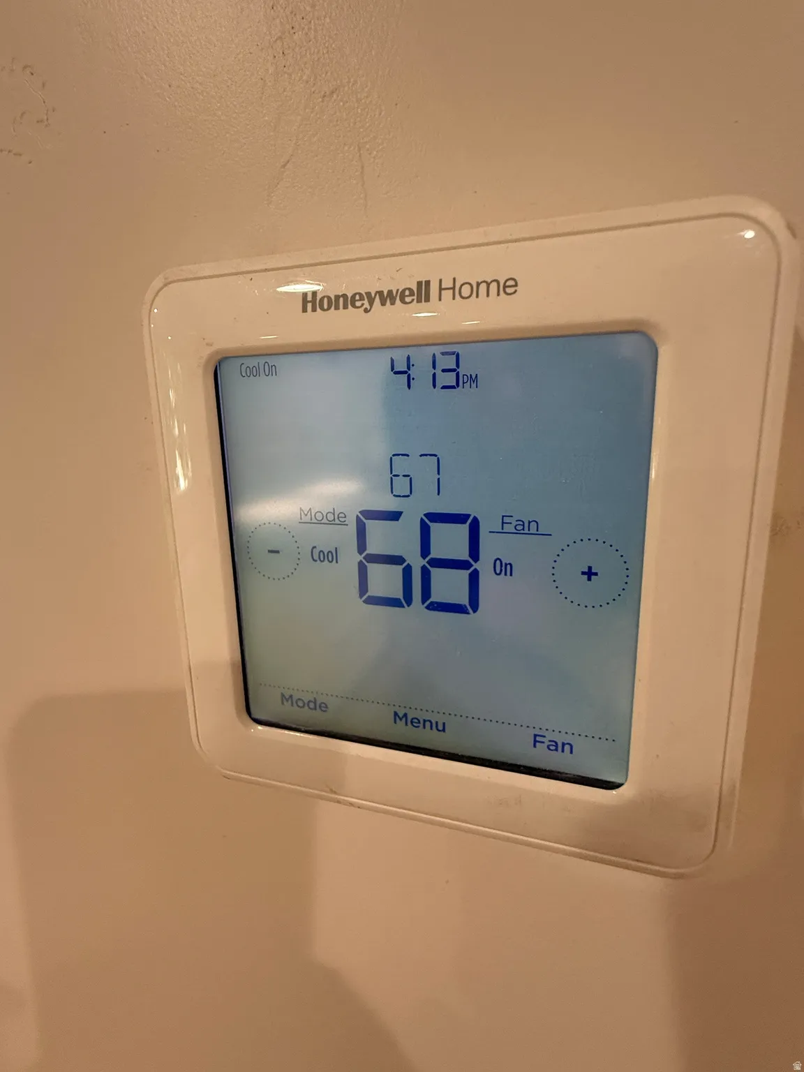 Honeywell Home digital thermostat featuring a backlit display and manual controls