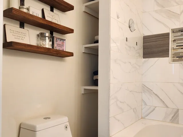 Contemporary bathroom featuring wood-finish flooring and a white built-in bathtub