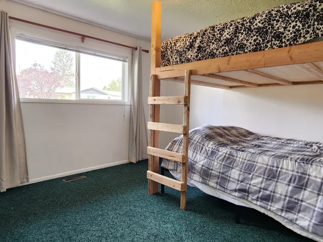 Wall-to-wall carpeting with a large window and window treatments