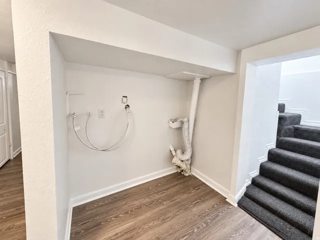 Dedicated laundry area featuring hookups and wood-finish flooring