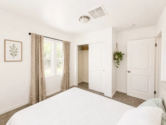 Carpeted flooring, white interior doors, and a double-pane window