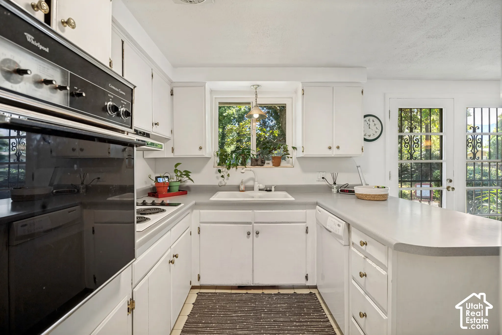 U-shaped kitchen with white cabinetry and a built-in oven