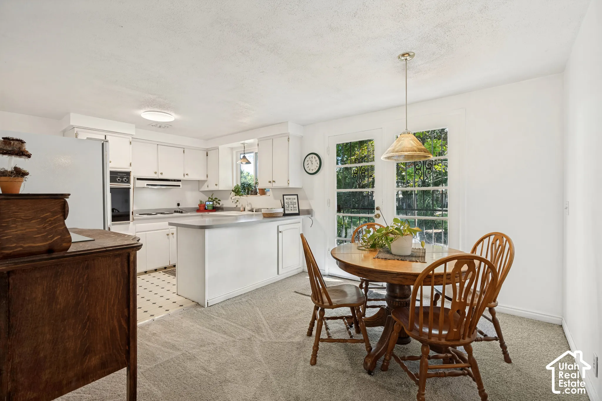 Kitchen area featuring white cabinetry, a built-in oven, and a cooktop