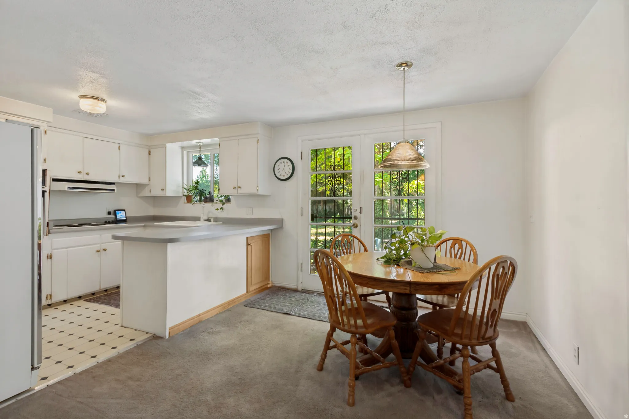 Kitchen with white cabinetry, a built-in oven, and a kitchen island with gray countertops