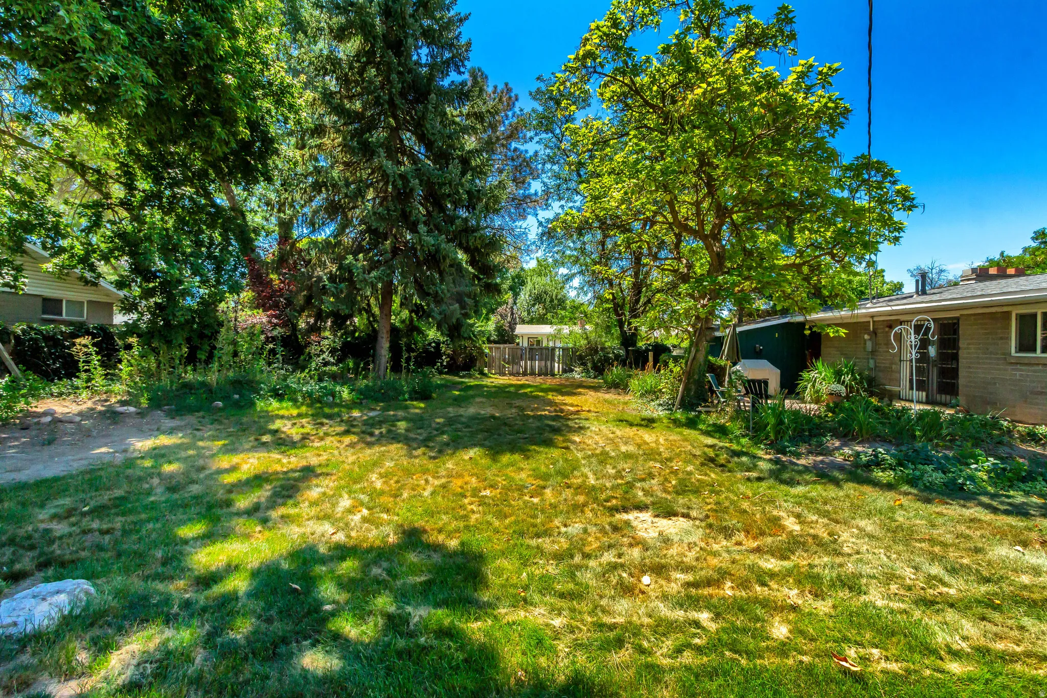 Expansive lawn with mature trees and established landscaping