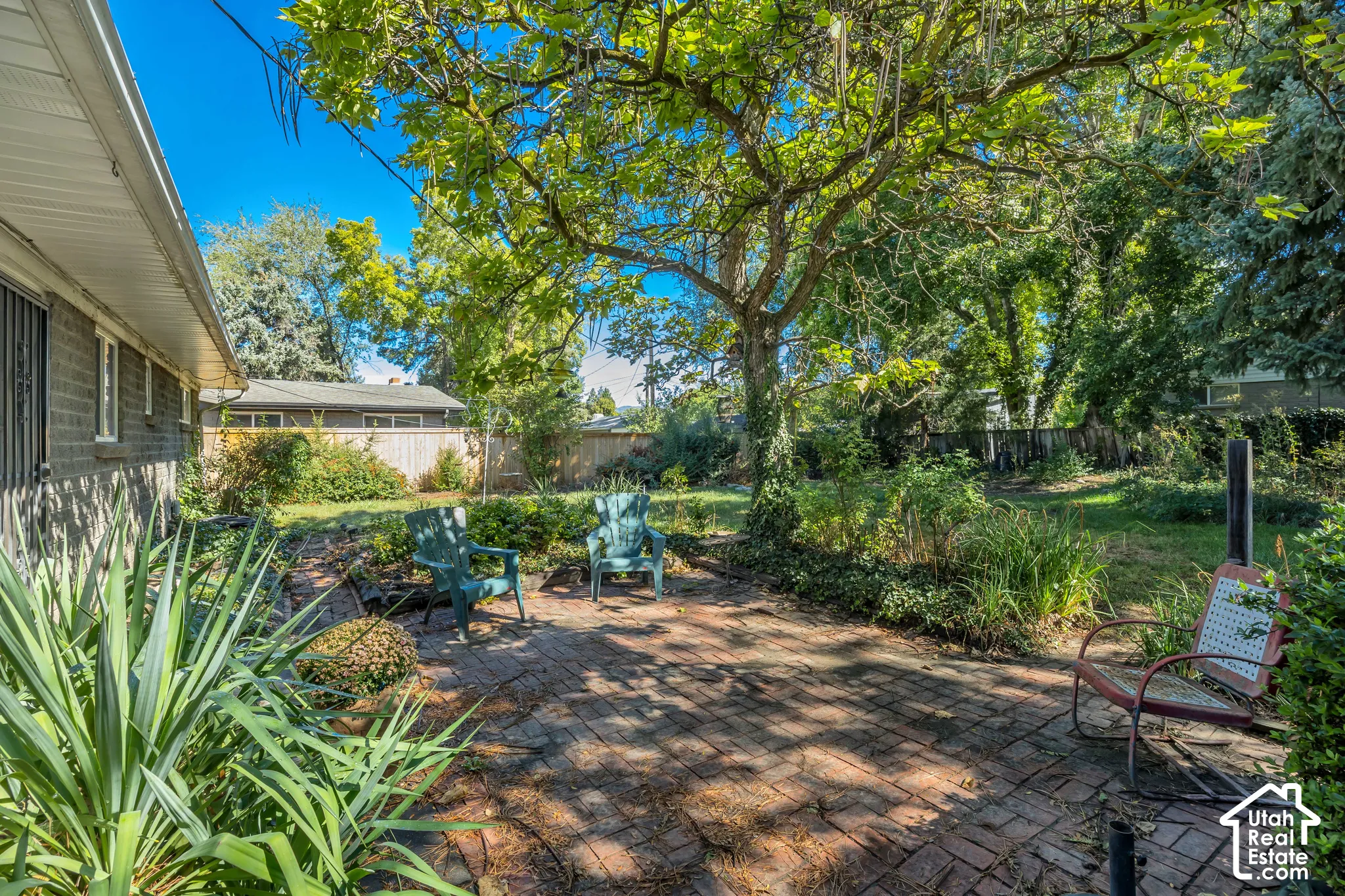 Brick patio featuring mature trees and established landscaping