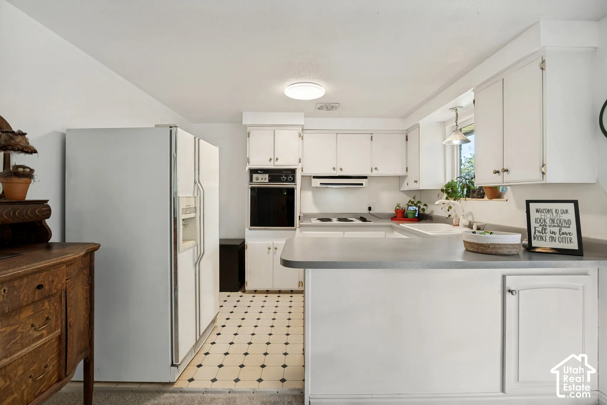 Kitchen featuring white cabinetry, built-in oven, range cooktop, recessed lighting, and patterned flooring