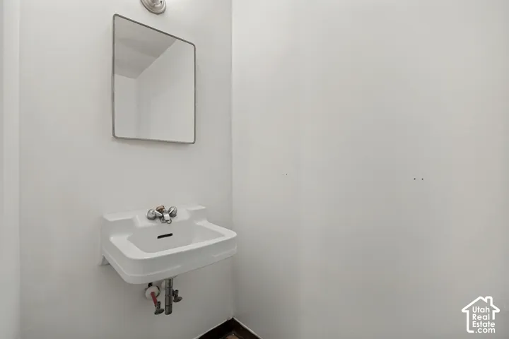 Wall-mounted sink with chrome-finish fixtures and an overhead rectangular mirror