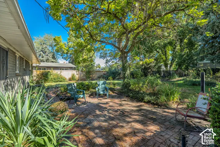 Brick patio featuring mature trees and established landscaping