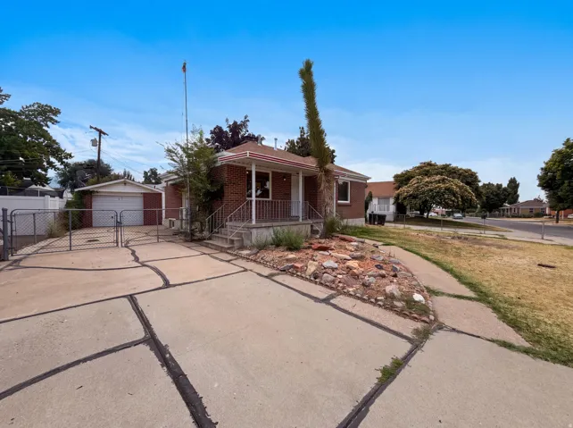Brick exterior residence featuring a covered front porch, concrete steps, and a decorative rock bed