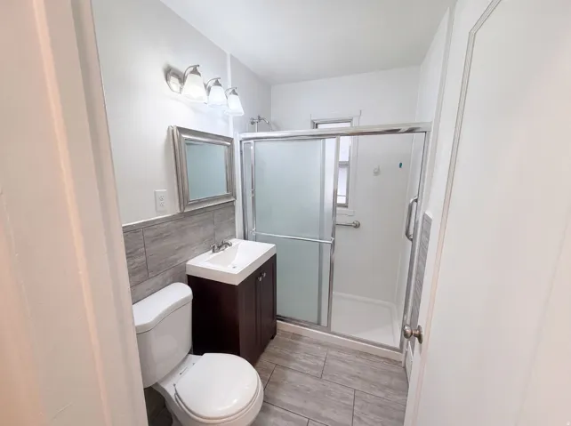 Bathroom with wood-finish vanity, integrated sink, and tiled flooring