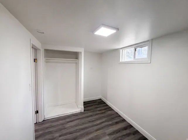 Wood-finish flooring, recessed lighting, built-in closet with hanging rods, white trim, and an egress window