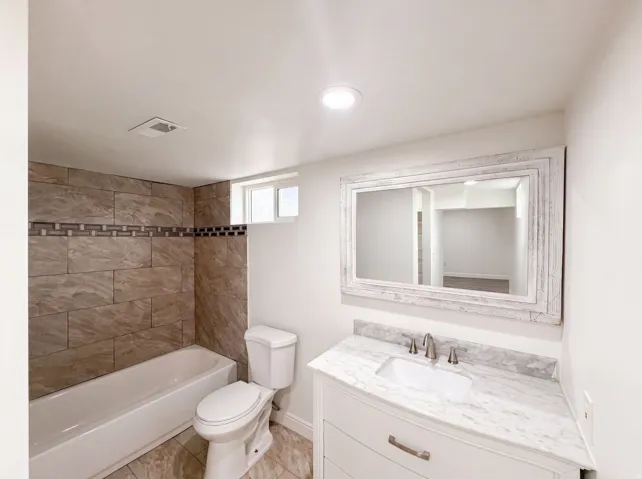 White vanity with curved front, integrated sink, and stone countertop