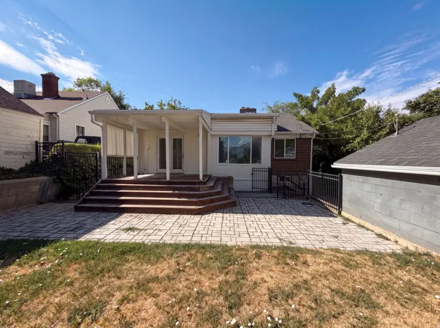 Expansive paver patio with a covered porch featuring multiple columns