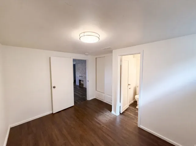 Wood-finish flooring, built-in storage, flush-mount ceiling light, and white interior doors
