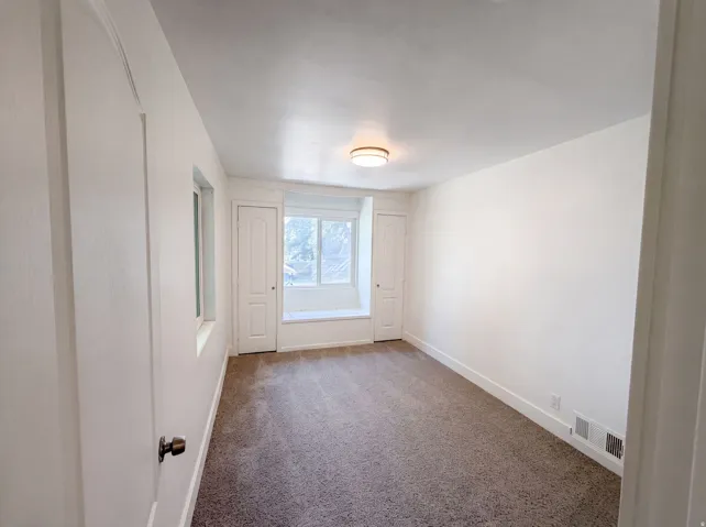 Recessed window seat, integrated storage cabinetry, overhead lighting, and carpeted flooring